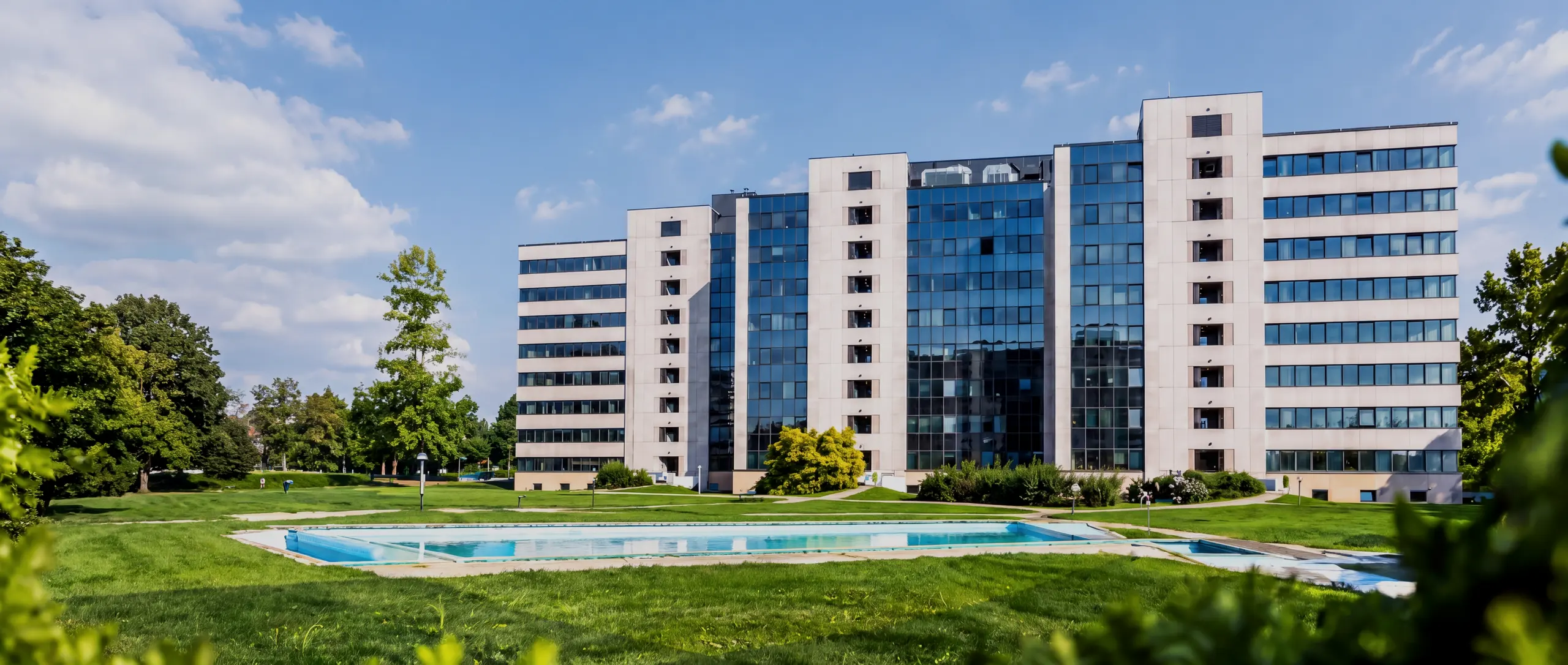 Ensemble de bureaux vitre en plein jour, pelouse et bassin au premier plan